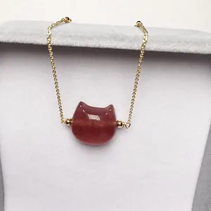 Macro shot of cat-shaped strawberry quartz pendant on a delicate gold O-chain necklace