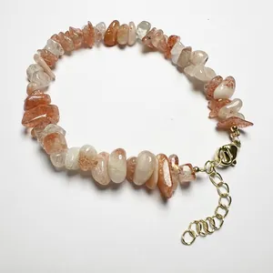 Detail of natural orange sunstone chip bead bracelet with gold lobster clasp and chain