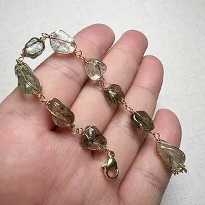 Bracciale artigianale con tormalina e quarzo grezzo avvolti in filo dorato e catenella