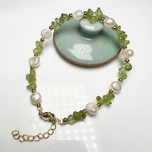 Close-up of baroque pearl bracelet with green peridot gravel and adjustable gold clasp