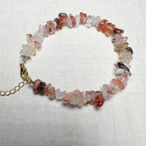Macro detail of natural green fluorite and flower crystal chip bracelet with golden clasp