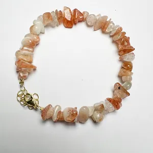 Detailed macro of natural peach crystal beaded bracelet with golden adjustable lobster clasp