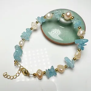Detail of baroque pearl bracelet with blue gemstones and gold lobster clasp closure