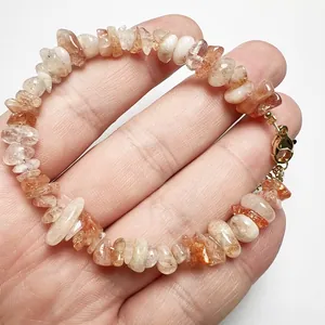 Detailed shot of natural sunstone and crystal stone chip bracelet with gold lobster clasp