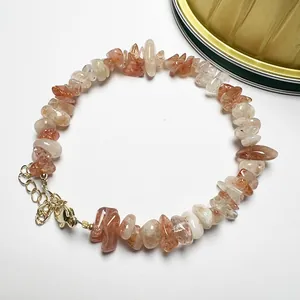Detailed view of natural sunstone chip beads bracelet with golden lobster clasp and chain