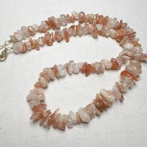 Macro detail of natural sunstone beaded necklace with golden lobster clasp and extension