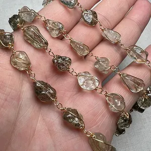 Vista dettagliata di pietre di tormalina avvolte a mano su un bracciale dorato