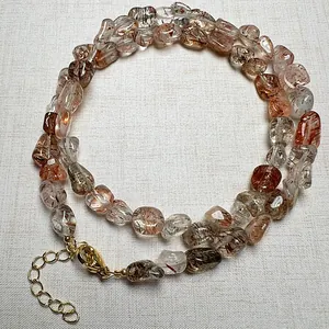 Macro detail of natural rutilated quartz crystal necklace with gold adjustable clasp