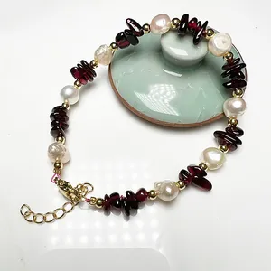 Close-up of Baroque freshwater pearl bracelet with red garnet stone and golden clasp