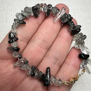 Natural black rutilated quartz chip bead bracelet with golden lobster clasp on fabric