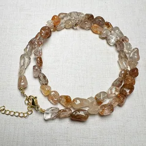 Detail of natural rutilated quartz necklace with gold lobster clasp and extension chain