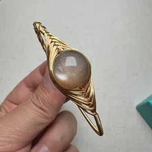 Macro detail of handmade wire-wrapped sunstone bracelet with 14K gold-filled metal wire