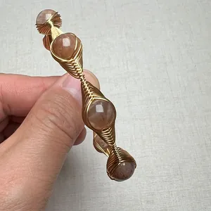 Detailed macro view of handmade gold wire-wrapped sunstone bracelet with natural gems