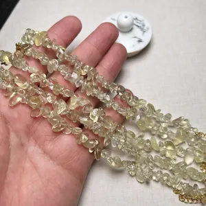 Vista dettagliata di perle in citrina gialla naturale su una catena d'oro con mano