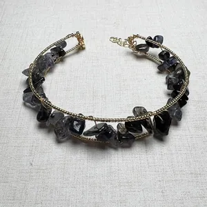 Macro view of gold wire wrapped choker featuring translucent dark grey natural stone chips