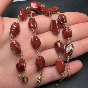Macro shot of handmade 14K gold-wrapped red gemstone bracelet with adjustable chain