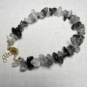 Macro shot of black rutilated quartz chip bead bracelet with gold lobster clasp