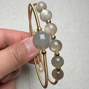 Macro detail of 14K gold wire wrapped bracelet featuring sunstone and natural pearls