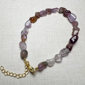 Close-up of a natural raw gemstone bracelet with various colorful tumbled stone beads