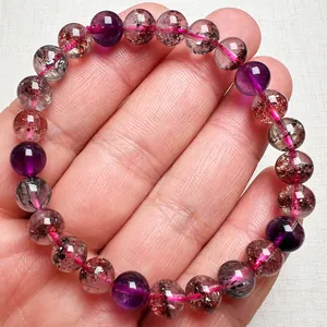 Makroaufnahme vom 8-10mm Super Seven Perlenarmband mit natürlichen Mineraleinschlüssen