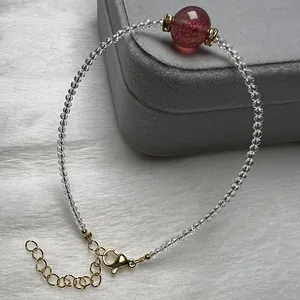 Close-up of strawberry crystal and white spinel beaded bracelet on jewelry box