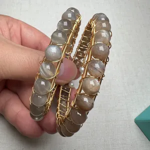 Detail showing handcrafted wire-wrapped sunstone beads and small pearls on an open cuff bracelet