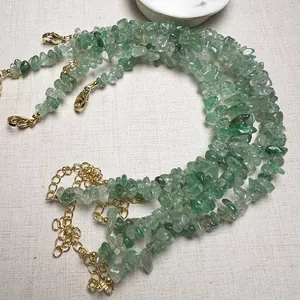Dettaglio del bracciale in cristallo verde con chiusura a moschettone e catenella dorata