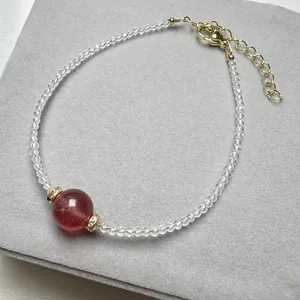 Detail of beaded strawberry quartz bracelet with white spinel and golden clasp extension