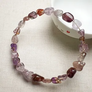 Bracelet en éclats de cristal d'améthyste naturelle sur fond zen minimaliste élégant
