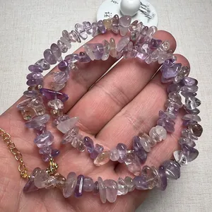 Dettaglio della mano con bracciale in ametista e cristallo naturale con catena dorata