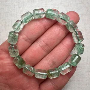 Nahaufnahme von grünem Phantomquarz-Armband mit einzigartigen fassförmigen Perlen