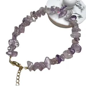 Bracciale di ametista naturale con chiusura regolabile dorata su sfondo bianco