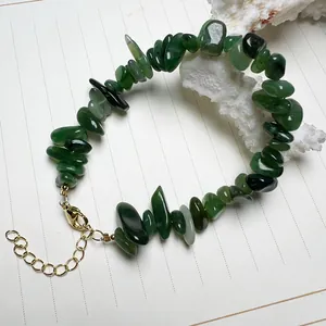 Detalle de pulsera de piedra jaspe verde con cierre de langosta dorado ajustable en blanco