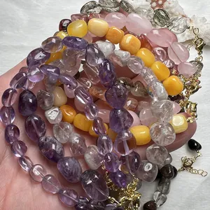 Dettaglio ravvicinato di bracciali in cristallo naturale con chiusure a moschettone