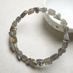 Détail macro de perles de labradorite naturelle sur un fil doré de haute qualité