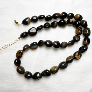 Dettaglio collana in occhio di tigre irregolare con chiusura a moschettone dorata