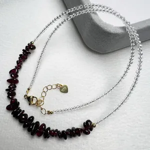 Macro view of a 925 silver beaded necklace featuring garnet stones and a gold lobster clasp