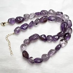 Collana con cristalli di ametista viola grezza e chiusura dorata su sfondo di pelliccia