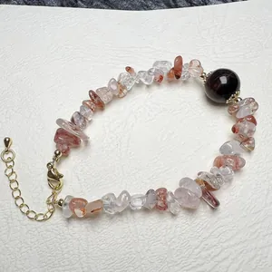 Detail of natural crystal chip bracelet with garnet bead and golden lobster clasp