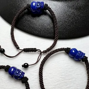 Detail of hand-carved lapis lazuli skull charm on adjustable woven rope bracelet