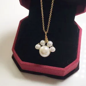 Detail of freshwater pearl cat paw pendant necklace in a red velvet jewelry box