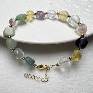 Makro-Detail von Naturkristall-Edelsteinarmband mit Goldperlen und Karabinerverschluss