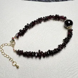 Detailed macro view of natural garnet chip stone bracelet with golden lobster clasp and chain