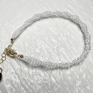 Close-up of woven spinel bead bracelet with faceted clear crystals and gold lobster clasp