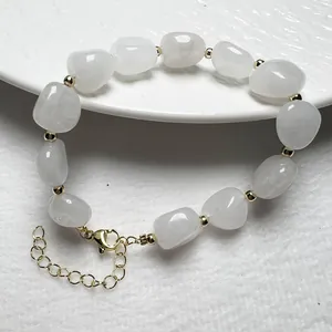 Detailansicht eines weißen Naturkristall-Armbands mit Goldperlen und verstellbarem Verschluss