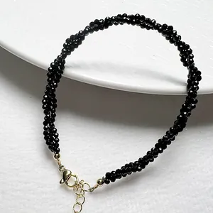 Detail of black faceted spinel woven bracelet with golden lobster clasp and chain