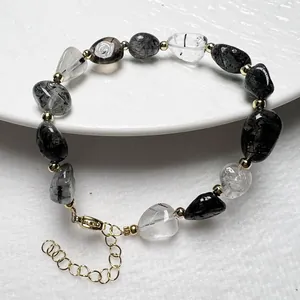 Detail eines Armbands aus unregelmäßigen schwarzen Rutilquarz-Perlen mit Goldakzenten