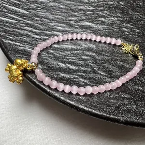 Roze kattenoog kralenarmband met gouden paardenhanger en verstelbare sluiting