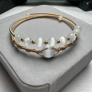 Macro detail of handmade 14K gold filled wire wrapped bracelet with white cat eye stones