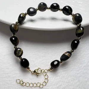 Detail eines Edelstein-Armbands mit goldenen Zwischenperlen und verstellbarem Karabiner